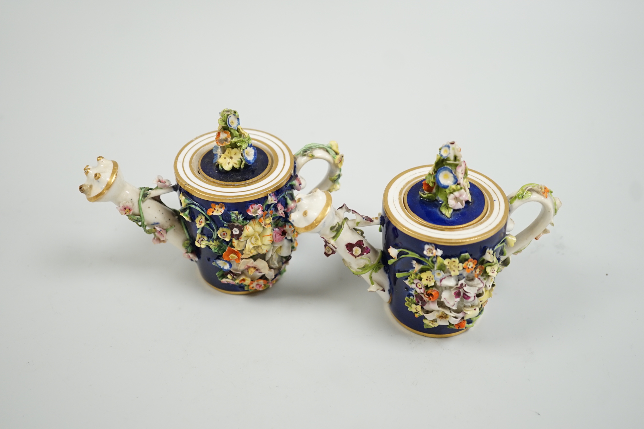 Toy porcelain. Two Bloor Derby flower encrusted rosewater sprinklers, each modelled as a watering can, c.1825, red printed marks, 9cm high